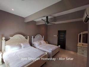 阿罗士打Jom Singgah Homestay - Alor Setar的卧室内的两张床,配有吊扇