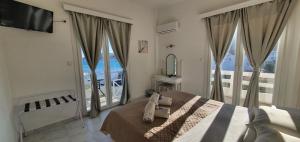 瓦里Syros Holidays的一间卧室设有一张床和一个大窗户