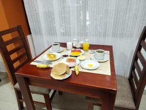 库斯科Dreams House Cusco的一张木桌,上面有早餐食品