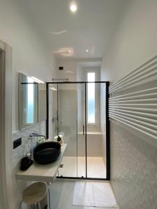 斯培西亚Affittacamere Flori的一间带水槽和玻璃淋浴的浴室