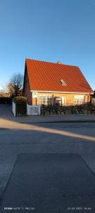 韦斯特兰Privates Domizil auf Sylt in Strandnähe的街道旁的一座带橙色屋顶的房子