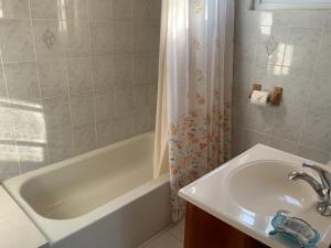 蒙特哥贝Poinciana House的一间带水槽、浴缸和淋浴的浴室