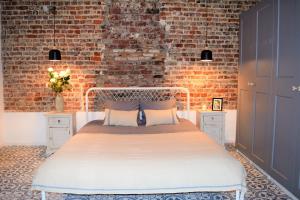 布鲁塞尔Home Sweet Home Brussels center的一间卧室配有一张砖墙床