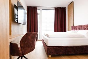 普拉特灵Boardinghouse Plattling的配有一张床和一张书桌的酒店客房