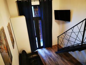 巴洛泰什蒂Kopel Haus - Studio - Self acces cod location的一间设有楼梯的房间,设有门和电视