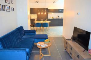 布鲁塞尔Home Sweet Home Brussels center的客厅配有蓝色的沙发和电视