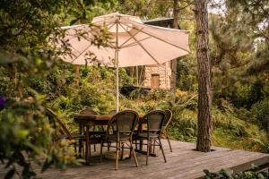 河内AMAYA HOME - Lodge, Spa & Restaurant的甲板上配有桌椅和遮阳伞