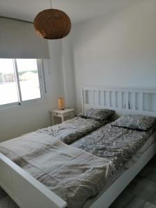 卡萨雷斯Casares Cozy Apartment的白色的卧室设有一张大床和一个窗户