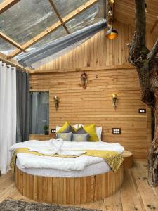 吉布Cloudwalk Treehouse的卧室配有一张木墙内的大床