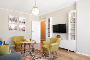 贝尔格莱德新城国际公寓式酒店的客厅配有两把椅子和电视