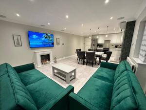 格林福德Luxury House的客厅设有绿色沙发和壁炉