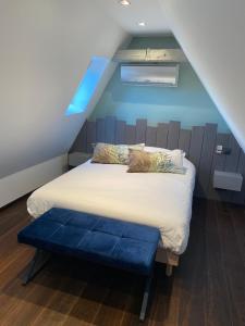 萨维尔纳La Mezzanine des Rohan Saverne的一间卧室配有一张蓝色墙壁的床