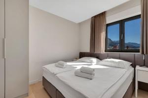 马卡尔斯卡Apartmani Vila Jelena的卧室配有一张带白色床单的大床和窗户。