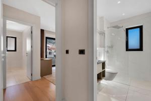 马卡尔斯卡Apartmani Vila Jelena的拥有白色墙壁的走廊和带卫生间的浴室