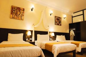 河内Perfume's Cozy House的酒店客房设有两张床和两盏灯。