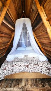 比利亚维哈Mana Star Lounge Hotel的小木屋内的一张床位,配有蚊帐