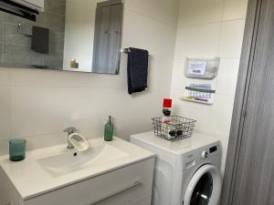 卡西卡斯Villa Phos的白色的浴室设有洗衣机和水槽。