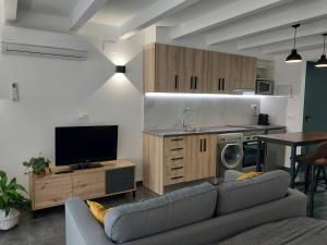 莫雷拉Loft 4 MORELLA的带沙发和电视的客厅以及厨房。