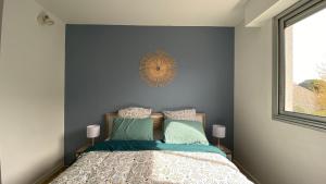 梅里尼亚克LE CYLIA的一间卧室配有一张蓝色墙壁的床和一扇窗户