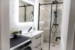 尼奥尔Appartement rénové - wifi - jardin - centre de Niort的白色的浴室设有水槽和淋浴。