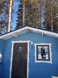 HammarstrandSchöne Stuga unmittelbar am Ammerån gelegen的蓝色的房子,有窗户和门