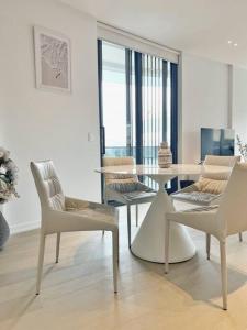 悉尼City view designed apartment in Bondi Junction的白色的客厅配有桌椅