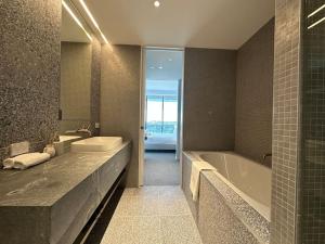 悉尼City view designed apartment in Bondi Junction的带浴缸、水槽和浴缸的浴室