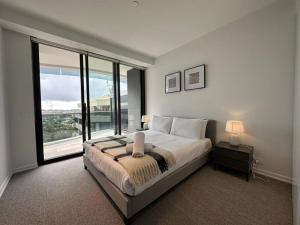 悉尼City view designed apartment in Bondi Junction的一间卧室设有一张大床和一个大窗户