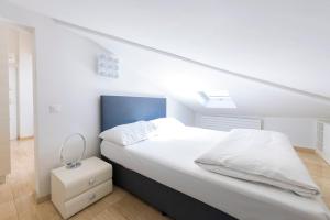 卢加诺San Carlo Apartments的一间卧室配有一张白色的床和蓝色床头板