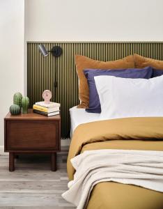 奥斯汀Midcentury Couples Designer Loft - Casa Tuya的一间卧室配有一张床和一张带仙人掌的边桌
