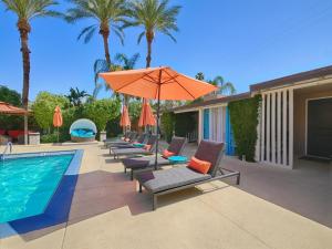 棕榈泉利特伊乐园酒店的一个带躺椅和橙色遮阳伞的游泳池