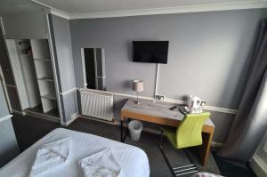 爱丁堡诺森伯兰酒店的一间卧室配有一张桌子、一张床和一台电视