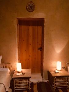 锡瓦Tanirt ecolodge的一间房间,门前设有两张桌子和蜡烛