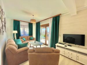 布德瓦Villa Serenity Budva的客厅配有2张沙发和1台平面电视