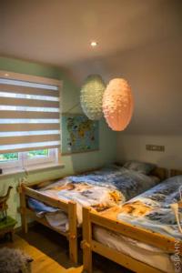 Sint-Gillis-WaasLe Petit Chalet avec hottub.的一间卧室配有一张床和两张纸灯笼
