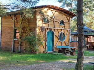 OsiecznicaMidgard的小木屋设有蓝色门和长凳