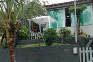 尼泰罗伊Casa em Camboinhas, Niterói, RJ的棕榈树和白色遮阳伞的房子