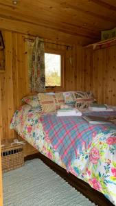 奥斯威斯Willowdene shepherds hut的小木屋内一间卧室,配有一张床