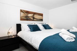 海若克利欧Maisonette near Heraklion Center Candia Maisonette的一间卧室配有两张带蓝白色枕头的床
