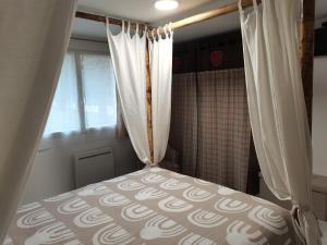 CastelsLe clos Le Roc Rouge的一间卧室配有一张带窗帘的床和淋浴