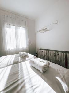 贝尔加El Segon Pis的一间白色卧室,床上配有2条毛巾
