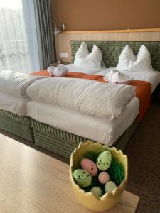 佩奇Várfal Wellness Panzió的酒店客房带两张床和一篮鸡蛋