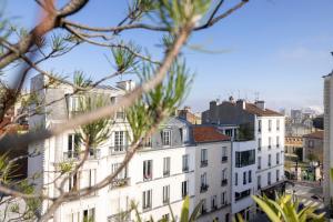 巴黎Maison Lavaud的从树后方可欣赏到建筑的景色