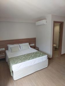 佩德拉阿祖尔Flat Hotel Pedra Azul的卧室配有一张白色大床
