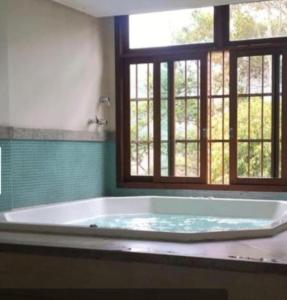 佩德拉阿祖尔Flat Hotel Pedra Azul的带窗户的浴室设有大浴缸