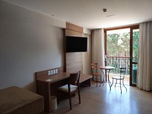佩德拉阿祖尔Flat Hotel Pedra Azul的酒店客房,配有一张床和一张桌子及椅子