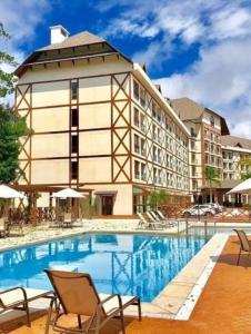 佩德拉阿祖尔Flat Hotel Pedra Azul的大楼前设有游泳池的酒店