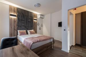 萨拉热窝Casa ARTEE Free Parking的一间卧室设有一张床和木墙