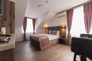 萨拉热窝Casa ARTEE Free Parking的酒店客房设有一张床和两个窗户。