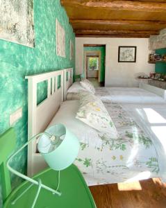SospiroloCasa delle Arti Fattoria dei fiori的一间卧室设有一张带绿色墙壁的大床